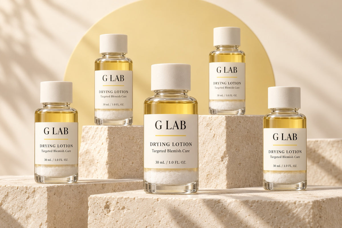 Five G Lab Drying Lotion bottles on sunlit stone blocks